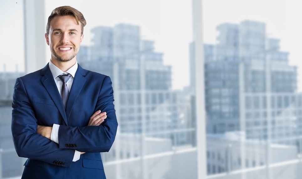 Businessman standing with arms crossed in office